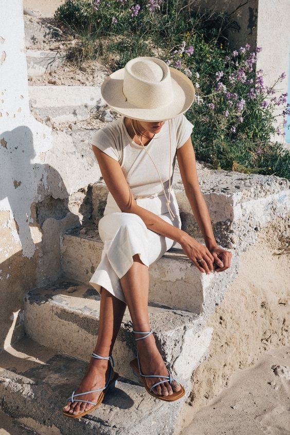 a neutral t-shirt, white linen pants, blue lace up sandals, a white straw hat are all you need for ultimate comfort