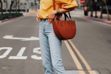 35 a yellow balloon sleeve off the shoulder top, light wahs slim crop jeans, brown slides, a brown semi circle bag