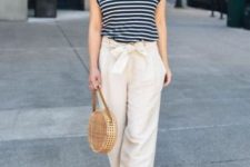 With beige and black wide brim hat, black and white striped shirt, beige rounded bag and high heels