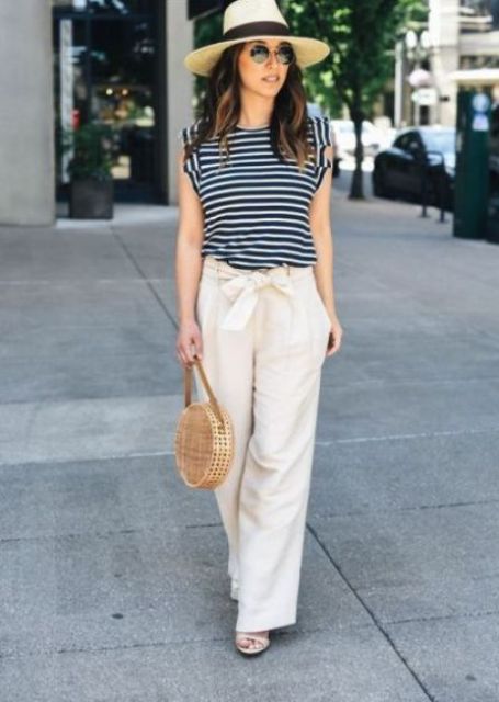 With beige and black wide brim hat, black and white striped shirt, beige rounded bag and high heels