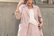 With beige loose top, beige leather bag and pale pink striped linen long blazer
