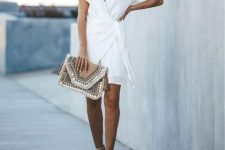 With embellished clutch and beige leather shoes