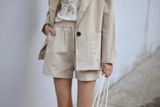 With floral button down shirt, beige linen blazer and white fishnet bag