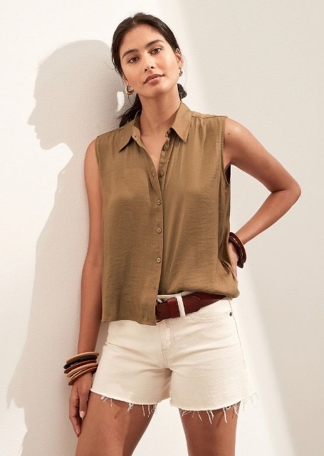 With golden rounded earrings, bracelets, brown leather belt and white denim shorts