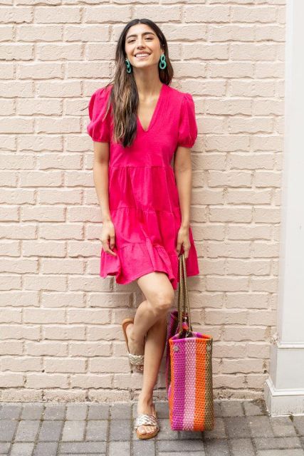 With green earrings, beige metallic flat sandals and orange, pink and pale pink striped tote bag