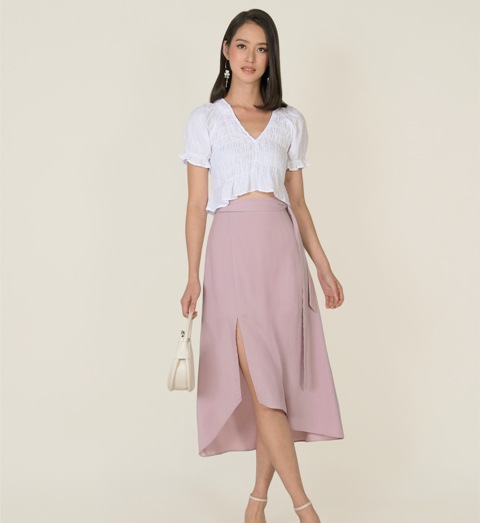 With white crop shirt, earrings, beige leather mini bag and beige shoes