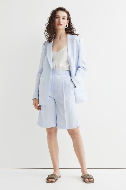 With white rounded earrings, white satin top, light blue linen long blazer and beige leather flat sandals
