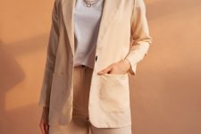 With white t-shirt, beige long blazer and golden necklace