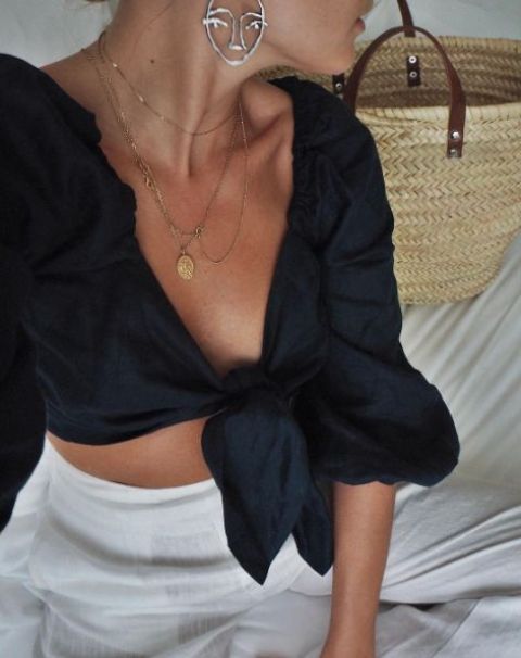 a black linen tie top, neutral linen high waisted pants, layered necklaces and statement earrings