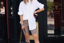 a bold summer look with an oversized white shirt, leopard print biker shorts, black slides and a black bag