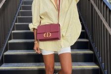 a bright summer look with an oversized yellow striped shirt, white biker shorts, white sneakers and socks, a mauve bag