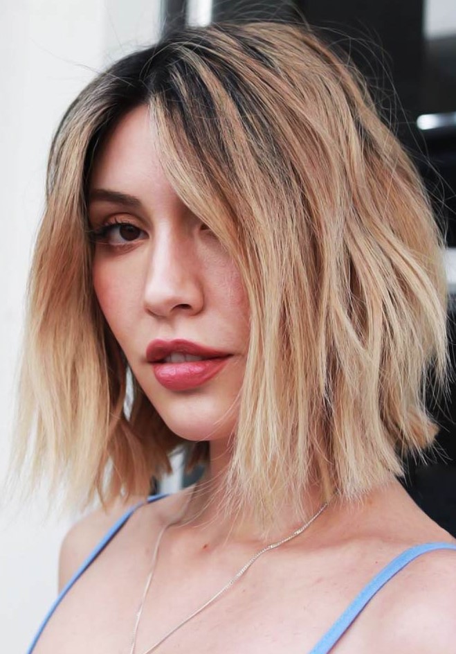 a delicate middle parted layered long bob with a darker root and beautiful caramel and blonde balayage is wow