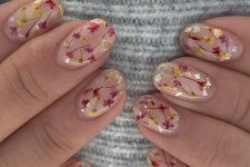 a delicate nude manicure accented with gold touches and purple and yellow dried blooms is great for summer or fall