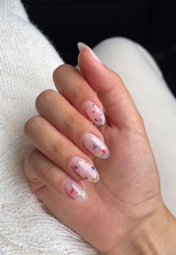 a lovely blush semi sheer manicure decorated with colorful dried flowers is a fantastic idea for a bride