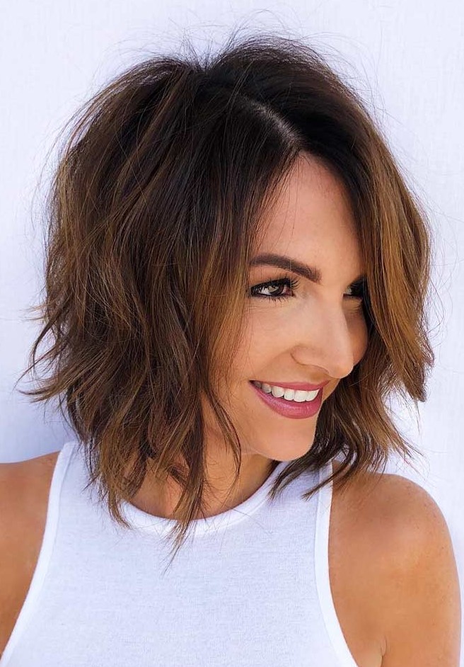 a messy layered bob with a darker root, with caramel highlights and slight waves catches an eye and looks fresh