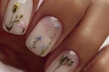 a milky manicure accented with various dired blooms placed as if they are growing on the nails is a lovely idea for spring