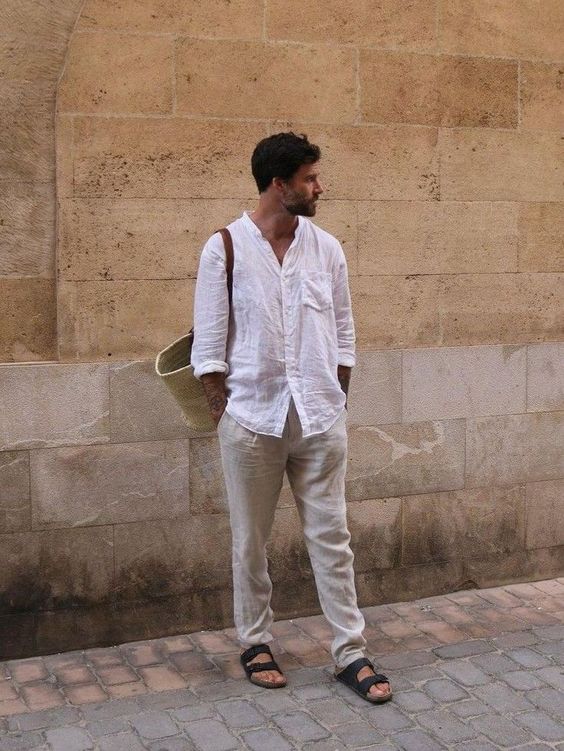 a pretty and comfy summer look with a white linen shirt, neutral linen pants, black birkenstocks and a woven bag