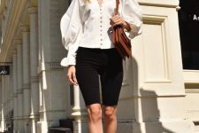a refined Parisian-inspired look with a white blouse with pearl buttons, black denim shorts, black strappy mules and a brown bag