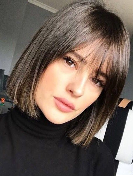 a refined and catchy deep brown liquid bob with wispy bangs looks retro-inspired and very stylish