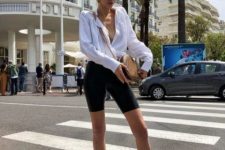 a refined summer look with an oversized white shirt, black biker shorts, black heeled mules and a brown bag