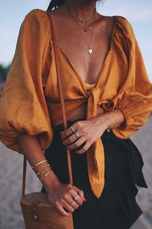 a sexy summer outfit wiht a mellow yellow knotted crop top with puff sleeves, a black linen shirt and a bucket bag