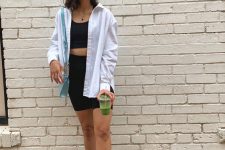 a sporty look with a black crop top and biker shorts, an oversized white shirt, white sneakers and socks, a light blue bag