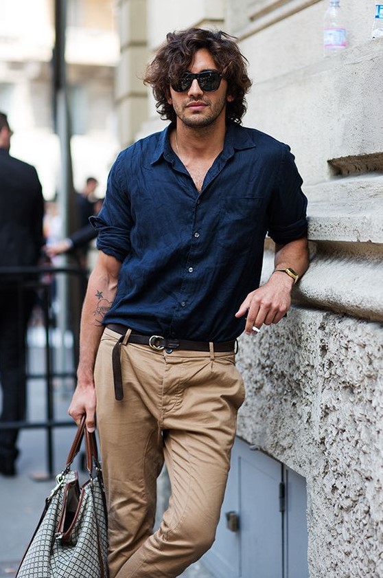 a stylish summer look with a navy linen shirt, tan pants, a black belt and a printed bag is a cool idea