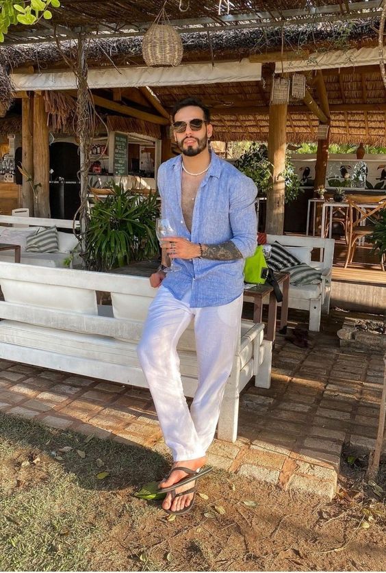 a summer vacation look with a blue linen shirt and white linen pants, a necklace and grey flipflops is an effortless idea