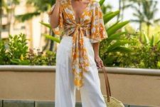 a vacation outfit with a bold yellow printed wrap crop top with bell sleeves, white linen pants, metallic shoes and a woven bag
