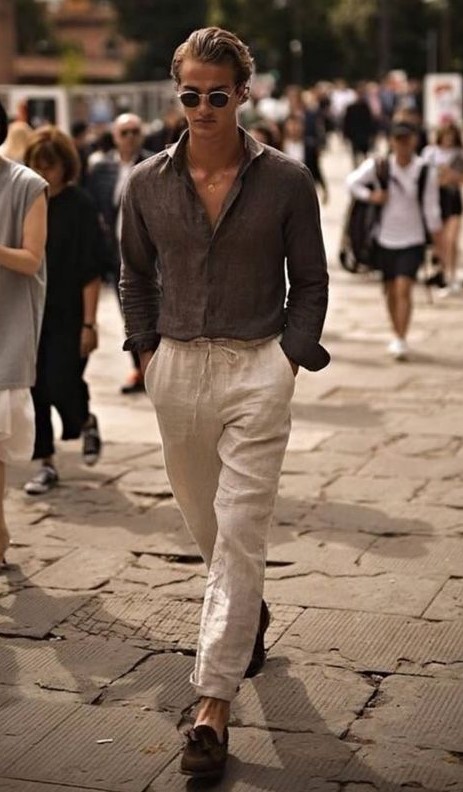 a very relaxed outfit with a grey linen shirt and neutral linen pants, brown moccasins and chic sunglasses