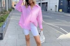 an oversized pink shirt, white biker shorts, white sneakers and pink socks, a white bag for summer