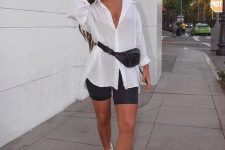 an oversized white shirt, black biker shorts, white chunky shoes and a black waist bag for a contrasting look
