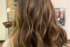 caramel babylights and balayge on dark brunette caucasian hair and long layers create a beautiful dimensional look