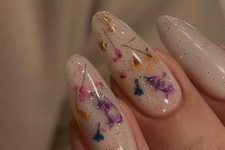 gold glitter milky nails accented with teal, pink and yellow dried flowers and gold leaf are great to add color to your look
