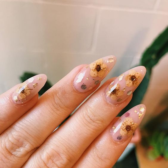 long coffin-shaped blush nails with bright dried blooms and gold leaf touches are great not only for summer but also for the fall