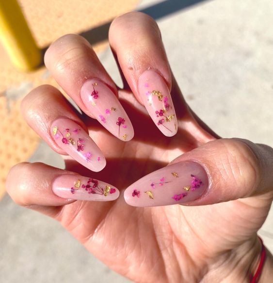 long coffin-shaped nails in blush accented with hot pink and purple dried blooms and gold leaf are great for a refined look
