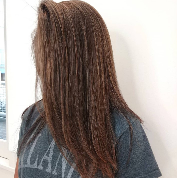 reddish brown long hair with subtle caramel babylights that add dimension and highlight the color of the hair