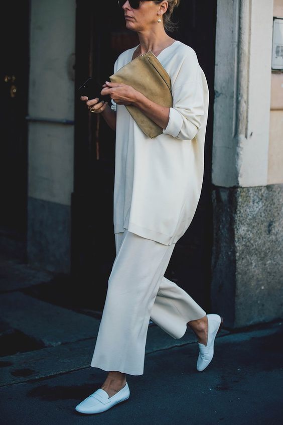 a minimalist fall work look with an oversized white jumper, wideleg pants, loafers and a neutral suede clutch