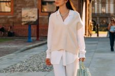 10 a relaxed white fall look with an oversized shirt, a tan waistcoat, white pants, a light green bag and white chunky shoes