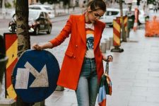 11 blue cropped jeans, a printed t-shirt, red shoes, an oversized red blazer and a bag with a colorful handkerchief