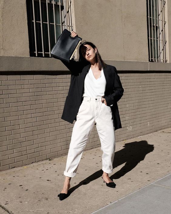 a fall work outfit with a white top, white cuffed jeans, black heeled mules, a black oversized blazer and a black bag