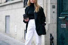 15 a contrasting outfit with a black turtleneck, a black oversized blazer, white jeans, red boots and a small black bag