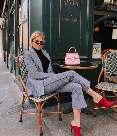 a grey pantsuit, a black turtleneck, red booties and a pink bag for a catchy work outfit in the fall