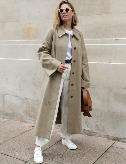 a neutral minimalist fall look with a white t shirt, white jeans, sneakers, a green grey midi trench, a brown bag