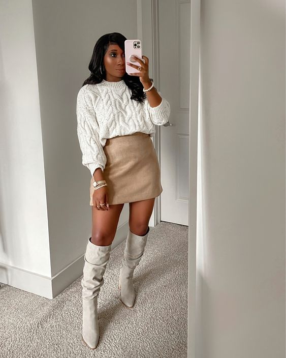 a neutral fall outfit with a white patterned jumper, a tan mini skirt, white knee boots and lovely pearl bracelets
