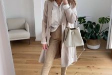 20 a neutral work outfit with a white shirt, tan trousers, an off-white trench, creamy combat boots and a creamy bag