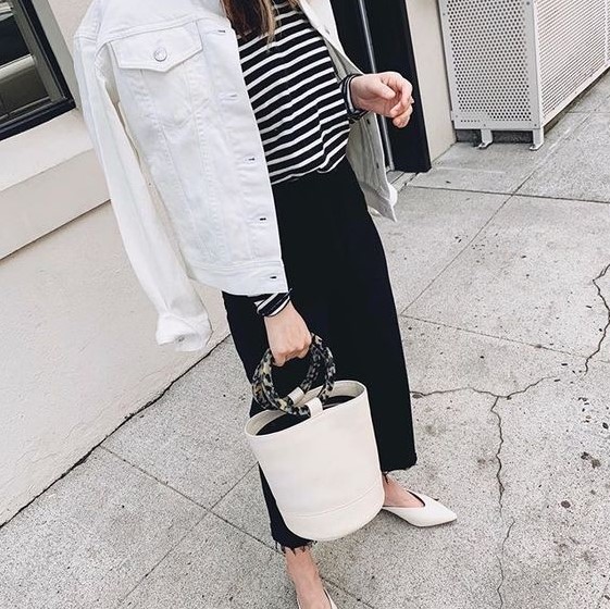 a striped top, a black denim midi skirt, a white denim jacket, white flats and a bucket bag