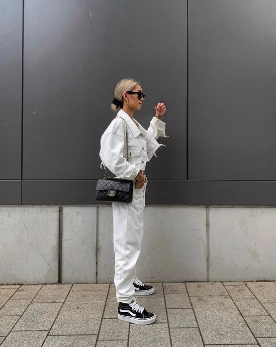 an all-white outfit with a denim jacket, jeans, black sneakers and a black crossbody bag