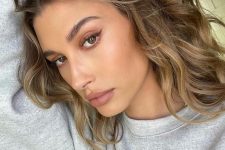 Hailey Bieber’s mousy brunette roots make for another amazing take on this cool color trend, with her subtle light ends