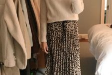 With beige loose cropped turtleneck sweater and beige pumps